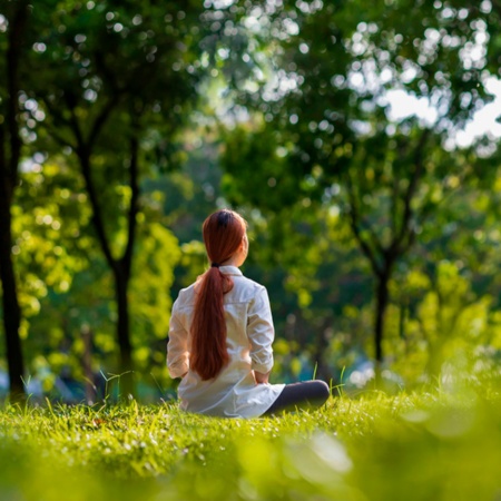 Mujer practicando meditación en el bosque