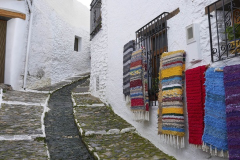 Uma rua típica de Pampaneira (Granada), enfeitada com as mantas tradicionais de La Alpujarra