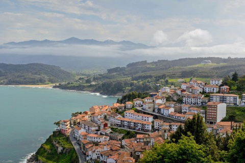 Blick auf Lastres mit dem Meer und den Picos de Europa im Hintergrund. Asturien