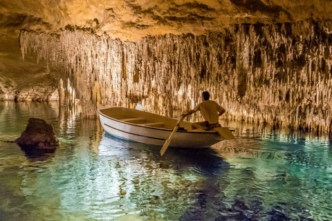 Mężczyzna w łódce wewnątrz Smoczych Jaskiń Drach na Majorce