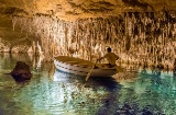 Homem numa lancha no interior das Cuevas del Drach (cavernas do dragão), em Maiorca.