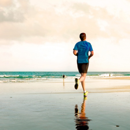 カナリア諸島グラン・カナリア島にあるマスパロマスビーチを走る若者