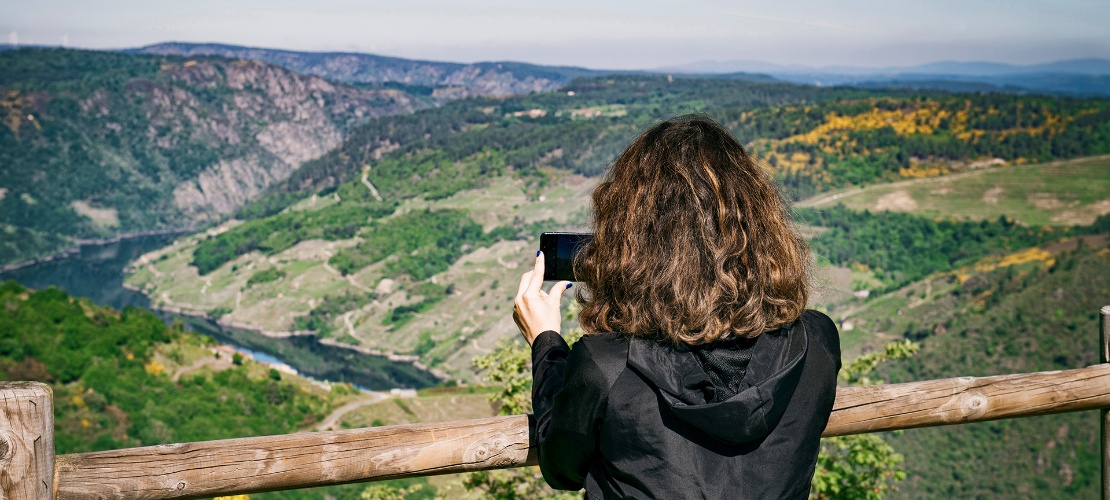 Tourist photographing the landscape from a viewpoint in La Ribeira Sacra
