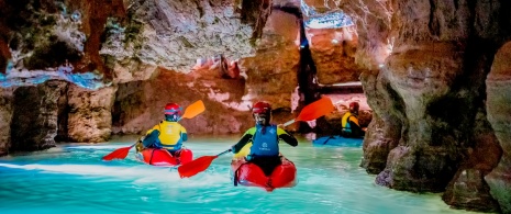 Turyści uprawiający kajakarstwo jaskiniowe w Coves de Sant Josep w La Vall d