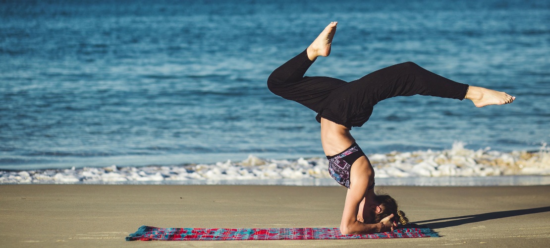 Girl practising yoga on the beach