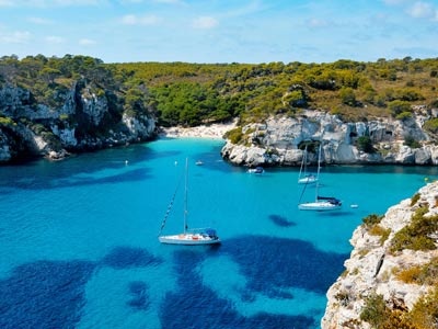 Boat dropping anchor in a cove in the Balearic Islands 