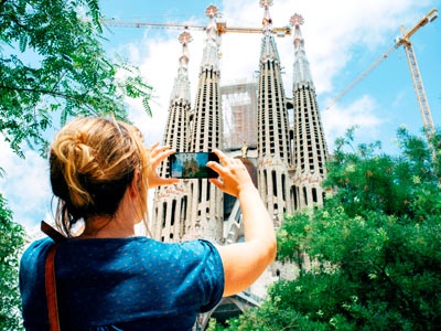  A woman taking a photo of the Sagrada Familia 