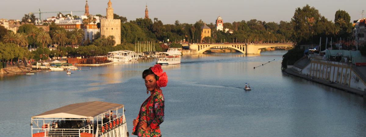 Flamenco dancer with the Torre del Oro and the river Guadalquivir in the background