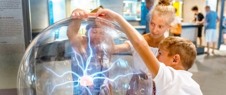 Children playing with a plasma ball at Cosmocaixa, Barcelona