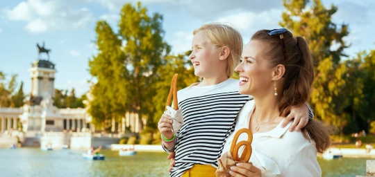 Mother and daughter eating some churros in the Retiro Park in Madrid, Region of Madrid