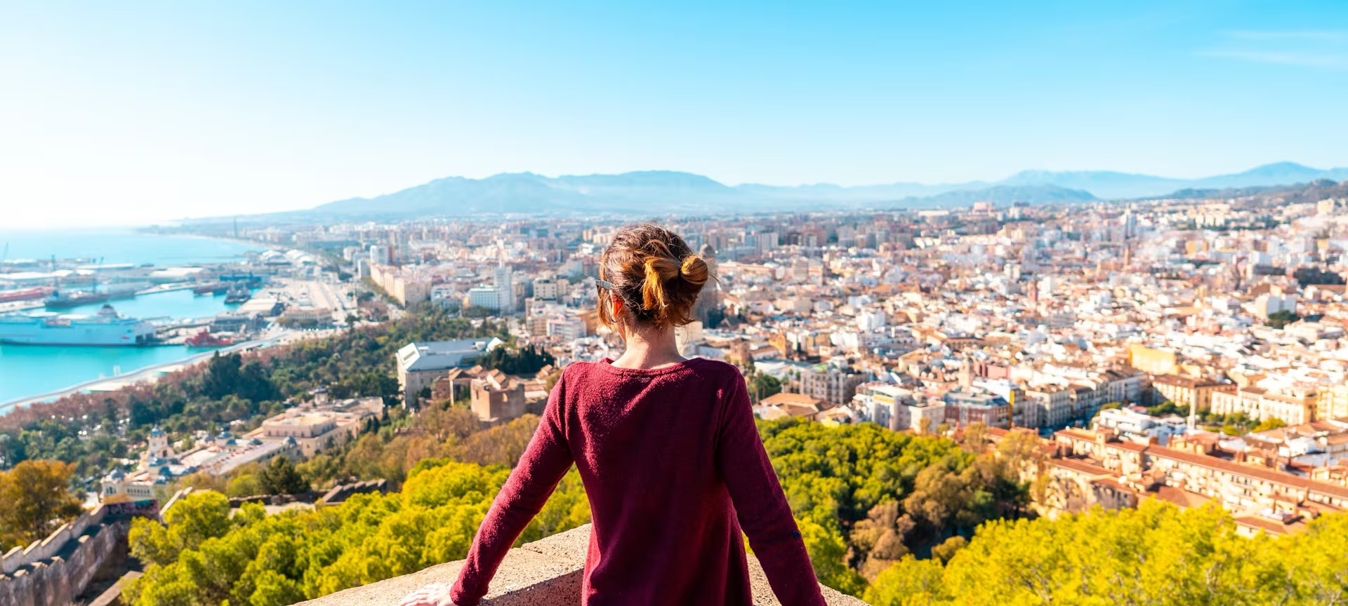 Tourist admiring the city of Malaga from Gibralfaro Castle, Andalusia Tourist admiring the city of Malaga from Gibralfaro Castle, Andalusia
