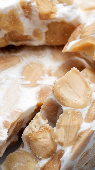 Dicke, unregelmäßig geschnittene Stücke von hartem Turrón