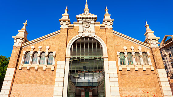 Die imposante Jugendstil-Fassade aus Sichtziegeln wird von einem großen Bogen in der Mitte durchbrochen