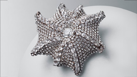 Asymmetrical starfish-shaped brooch with eight radial pear-cut crystal ribs, which stretch out from an oval Bohemian crystal