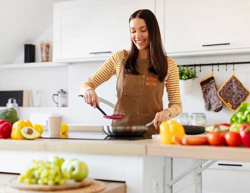 Mulher jovem cozinhando Mulher jovem cozinhando