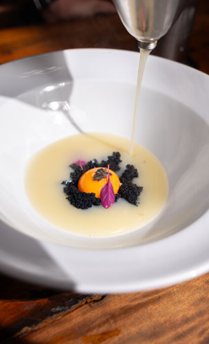 Gema orgânica em salsa de trufa negra com cogumelo e ovas tobiko, finalizada com creme de batata