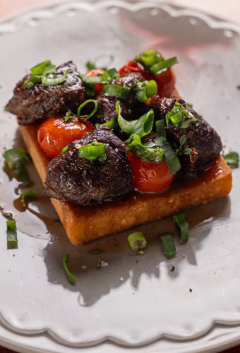 Polenta frita com bochecha de porco e tomates confit