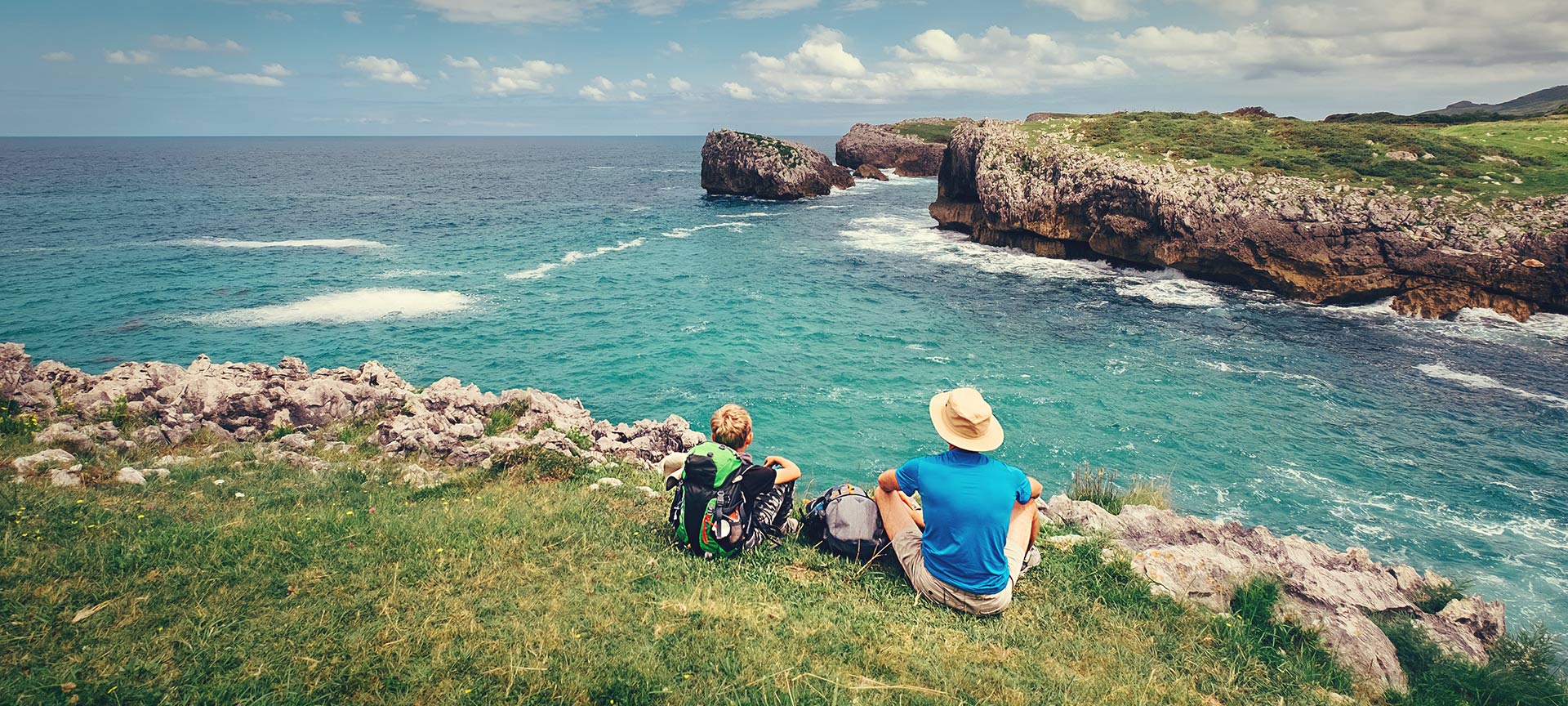 Pilgrims resting with a view of the coast on the Northern Way of Saint James