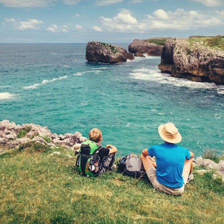 Pilgrims resting with a view of the coast on the Northern Way of Saint James