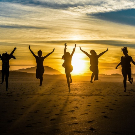 Des amis sur une plage de Galice au coucher du soleil