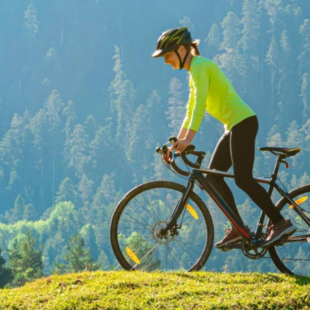 Женщина на велосипеде на фоне природы