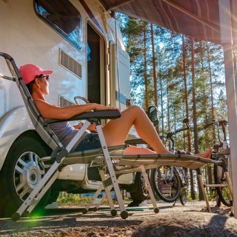 Tourist entspannt sich neben seinem Wohnwagen