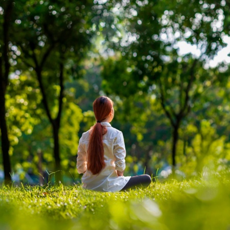 Una donna fa meditazione nel bosco