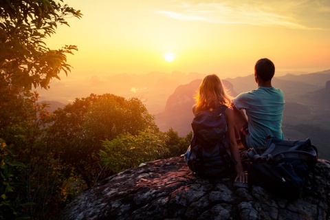 Ein Paar beobachtet den Sonnenuntergang in den Bergen.