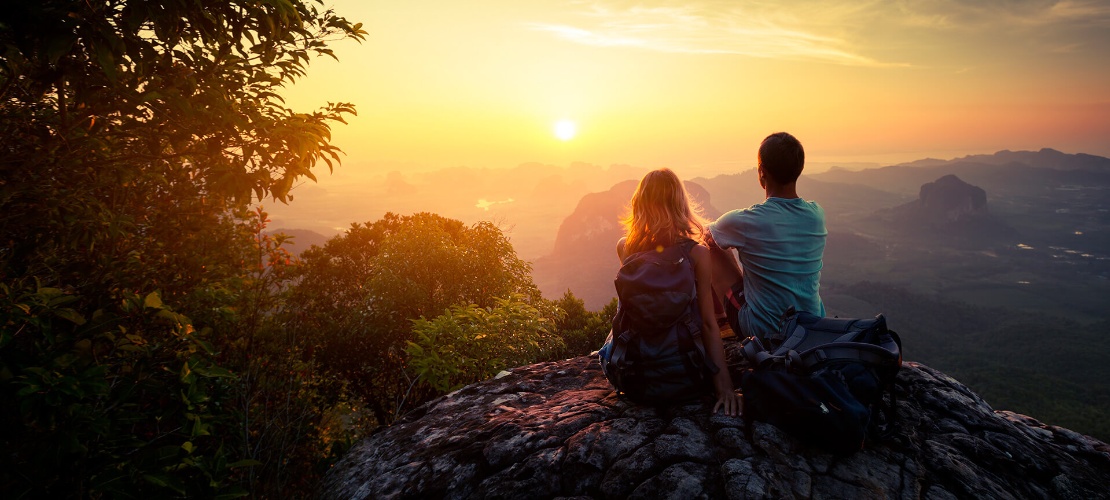 Couple admirant un coucher du soleil à la montagne