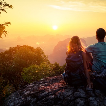 Couple admirant un coucher du soleil à la montagne