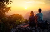 Ein Paar beobachtet den Sonnenuntergang in den Bergen.