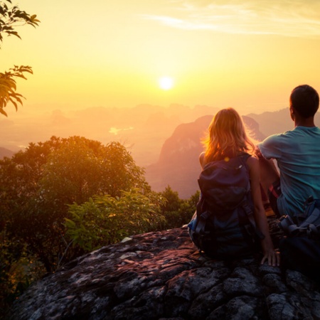 Coppia che contempla il tramonto in montagna