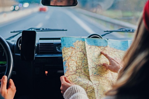 Chica consultando un mapa de España en un coche