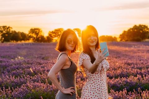 Pareja posando en un campo de lavanda durante el atardecer