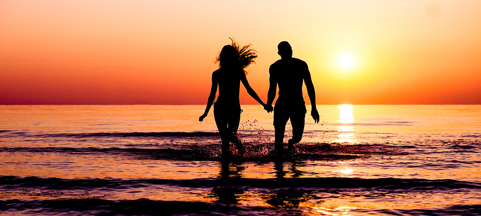 Couple profitant du coucher de soleil sur la plage
