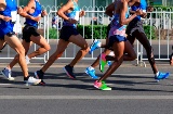 Zbliżenie na biegaczy biegnących w maratonie