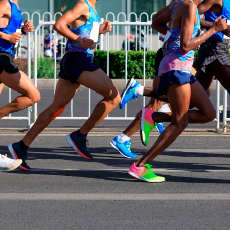 Zbliżenie na biegaczy biegnących w maratonie
