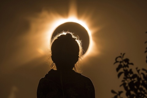 Silhouette einer Person, die sich die Sonnenfinsternis ansieht