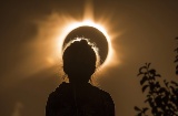 Silhouette einer Person, die sich die Sonnenfinsternis ansieht