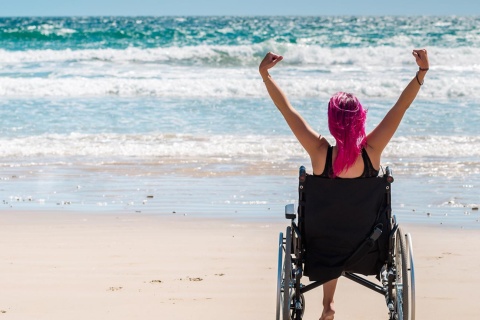 Touriste en chaise roulante sur la plage