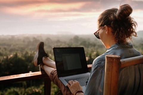 Moça trabalhando com vista para a natureza