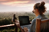 Junge Frau arbeitet mit Aussicht in die Natur