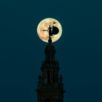 Silueta de la Giralda con la luna llena en Sevilla, Andalucía