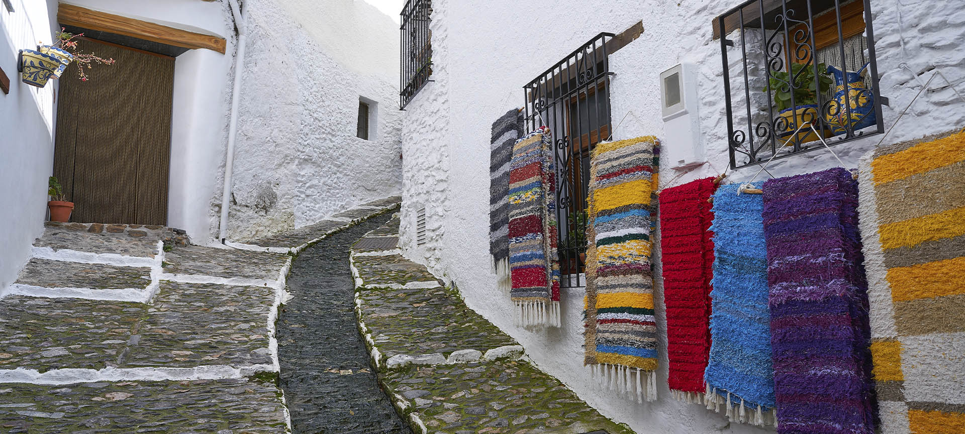 A typical street in Pampaneira (Granada), adorned with the traditional banners of La Alpujarra