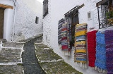 Una calle típica de Pampaneira (Granada), adornada con las mantas tradicionales de La Alpujarra
