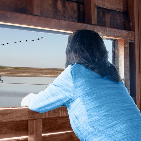 Frau beim Betrachten von Vögeln in einem Naturpark