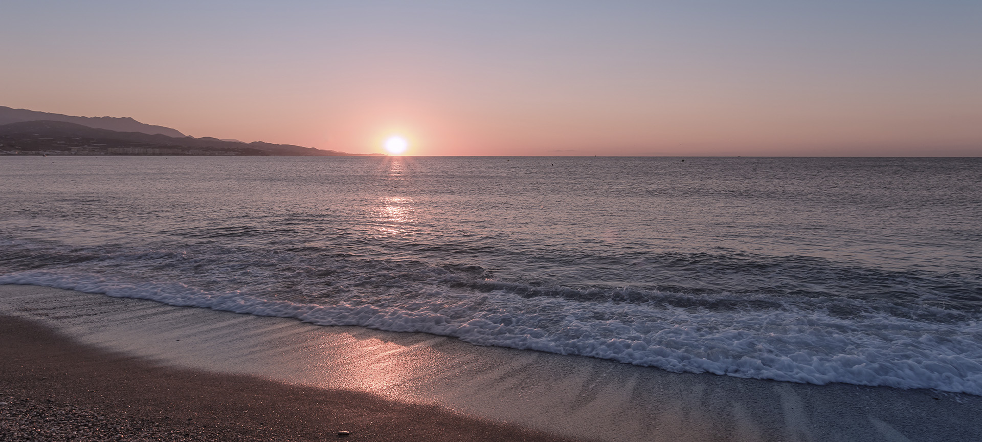 Sunset over a beach in Torre del Mar (Malaga, Andalusia)