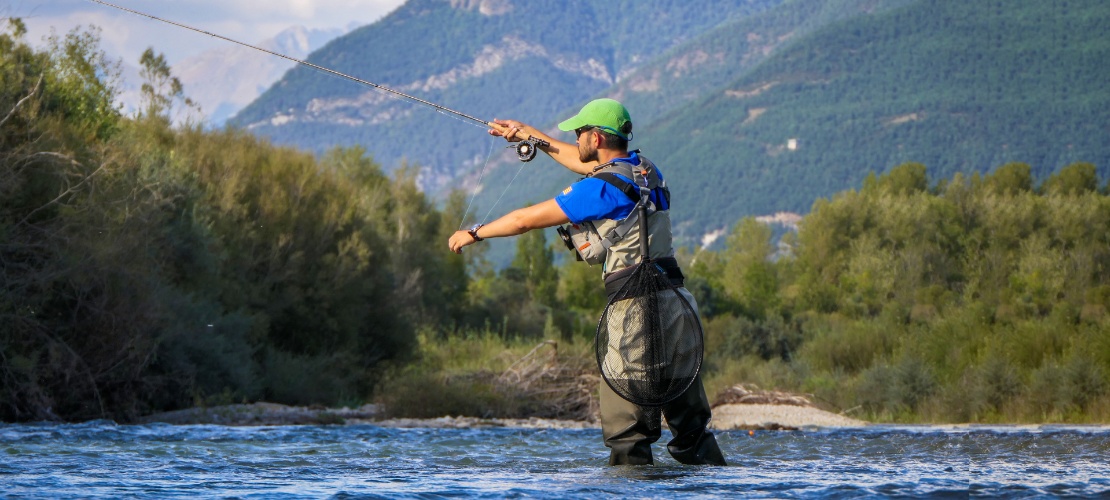 Турист ловит рыбу в реке Гальего в Уэске, Арагон, Испания