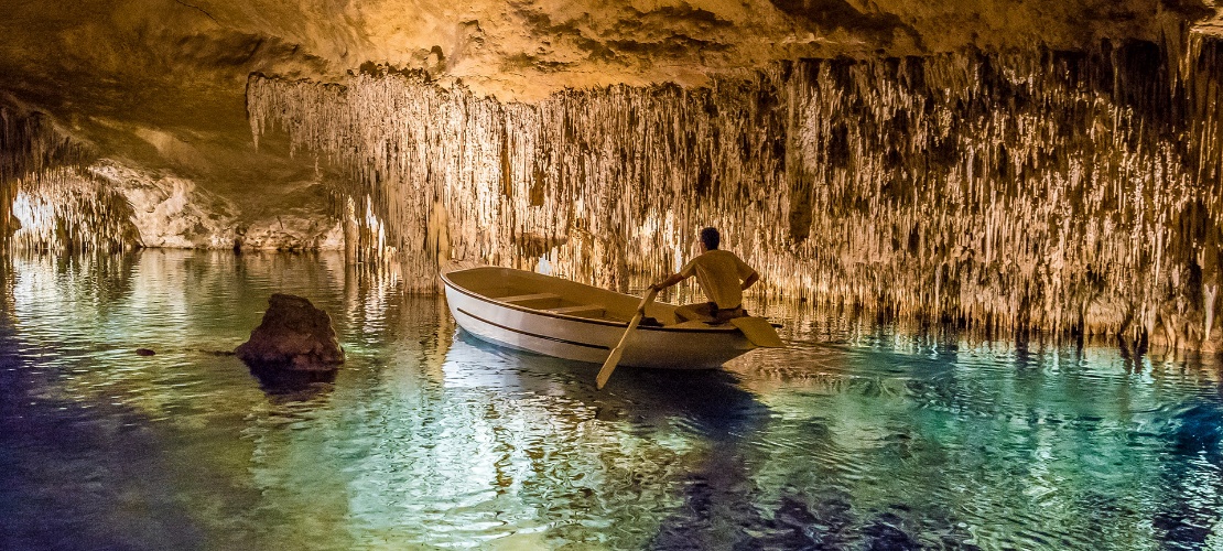 Mann in einem Boot in den Drach-Höhlen auf Mallorca