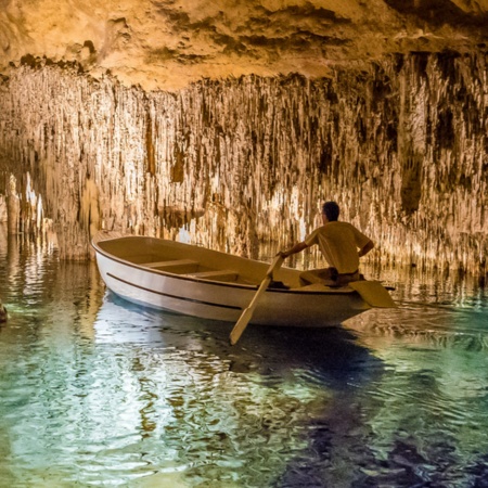 Mężczyzna w łódce wewnątrz Smoczych Jaskiń Drach na Majorce